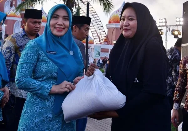 Pj Ketua Tim Penggerak PKK Sulsel, Sofha Marwah Bahtiar memberi bantuan beras kepada masyarakat di Makassar, Minggu, (17/3).