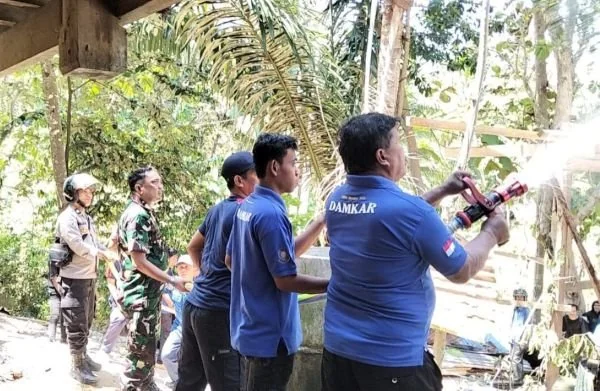 Damkar Majene bersama Babinsa dan Bahbinkamtibmas saat melakukan upaya pemadaman (Dok : Ist).