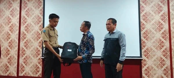 Tenaga Ahli Gubernur Sulbar, Hajrul Malik saat menyerahkan bantuan kepada perwakilan siswa kurang mampu di SMA 1 Kalukku(dok:Ist)
