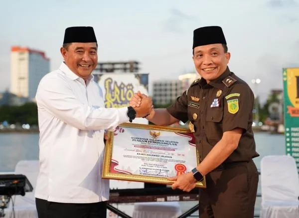 Pj Gubernur Sulsel, Bahtiar Baharuddin menyerahkan penghargaan kepada Leonard Simanjuntak, di Makassar, Rabu, (20/3).