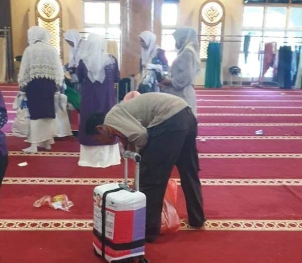 Salah satu personil Polres Jeneponto, saat membersihkan sampah berserakan didalam Mesjid Agung. (Ist).