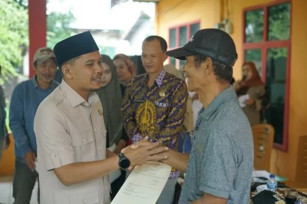 Wakil Bupati Jeneponto, Islam Iskandar, saat menyerahkan sertifikat kepada masyarakat penerima manfaat di Kelurahan Tolo (Dok : Ist).