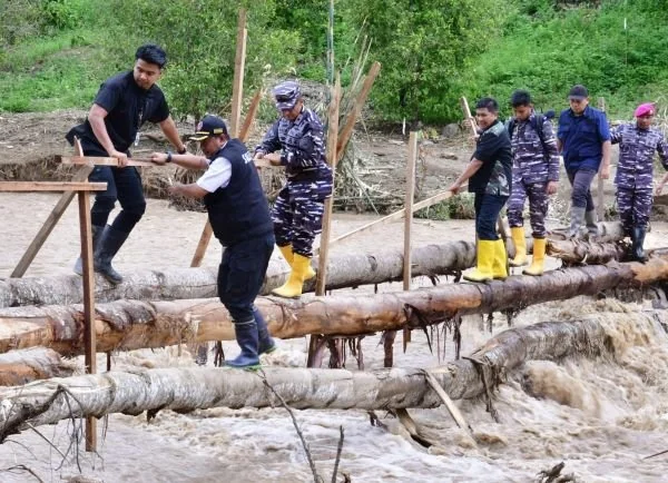 Pj Gubernur Sulsel, Bahtiar Baharuddin saat akan menemui warga korban bencana dengan melewati titian bambu sebagai jembatan darurat.