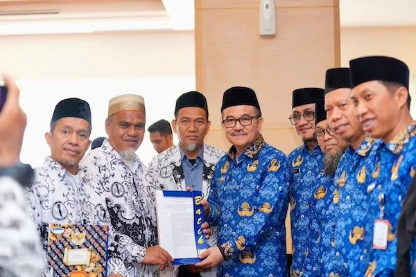 Sekprov Sulsel, Jufri Rahman, menyerahkan SK pengaktifan kembali kepada dua guru asal Luwu Utara, Rasnal dan Abdul Muis (dok. Ist)